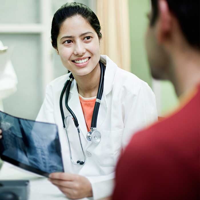 um médico a mostrar um raio-x a um paciente