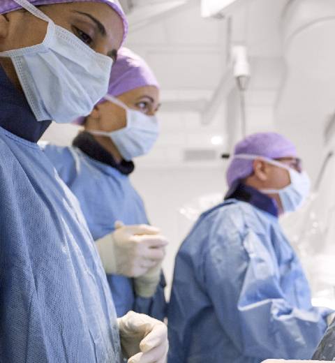 Um grupo de cirurgiões usando equipamento cirúrgico