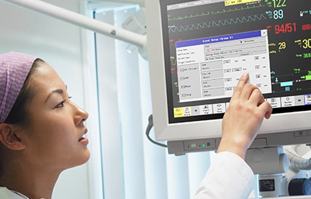 Clinician pointing to a monitor to get clinical decision support.