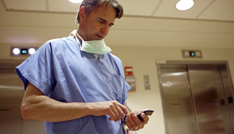 Um profissional clínico a visualizar os registos de um paciente num dispositivo móvel