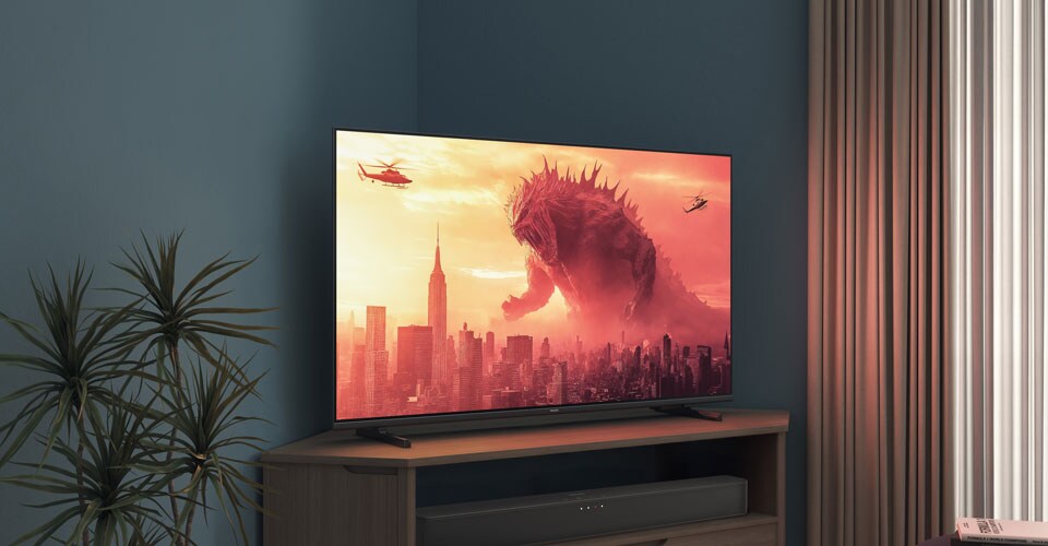 Uma TV Philips num suporte de canto exibe um filme do Godzilla