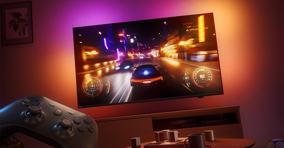 Um videojogo de corridas é exibido numa TV Philips Ambilight numa sala com pouca iluminação.